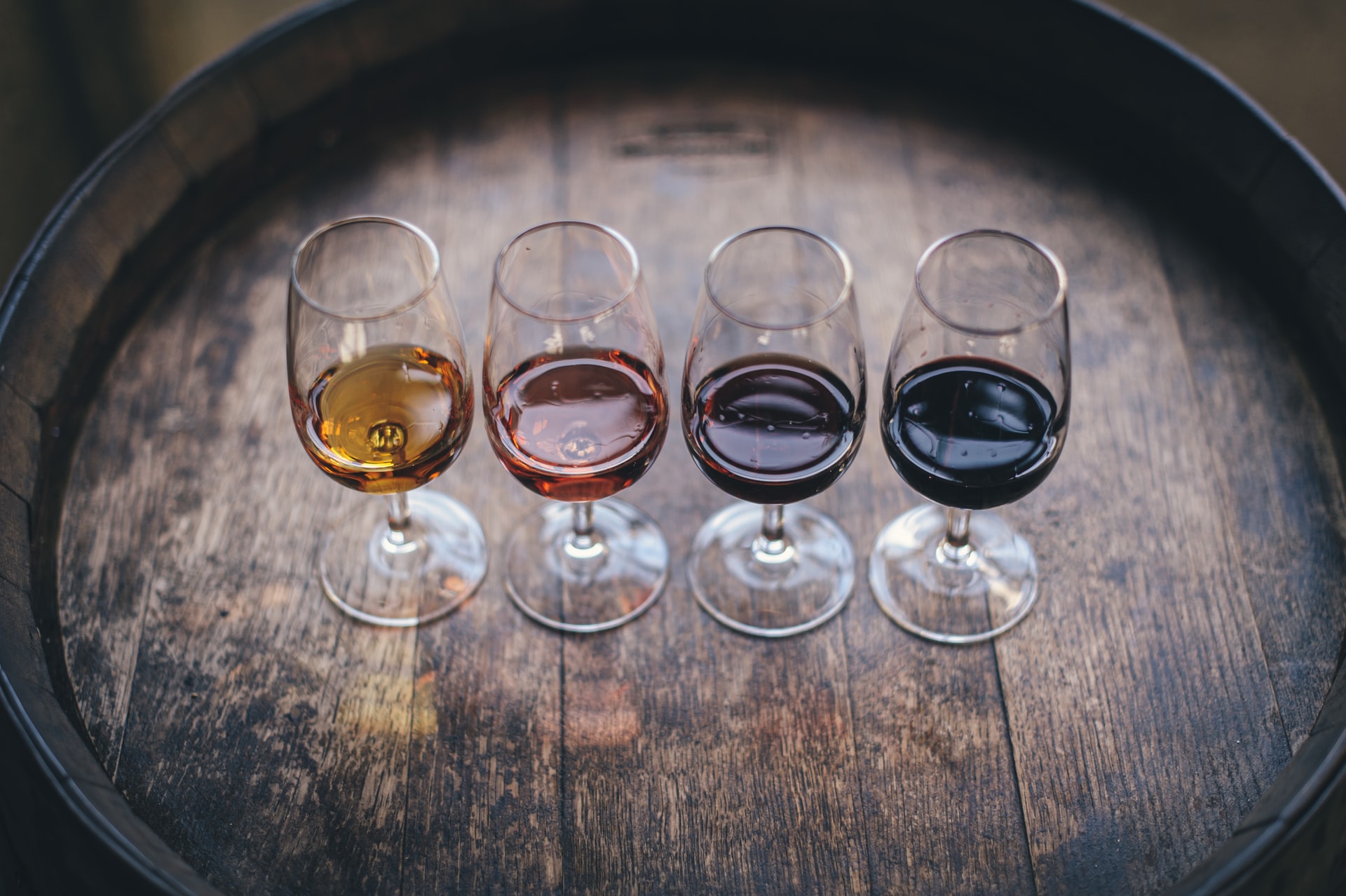 four glasses of wine on a barrel